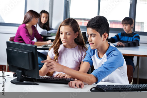 Photo: Teenage Friends Using Computer In Lab Teenage Friends Using Computer In Lab