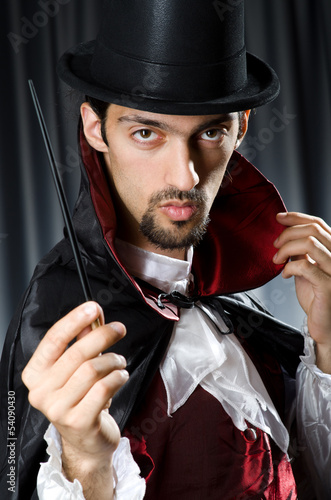 Photo: Magician in the dark room with wand Magician in the dark room with wand