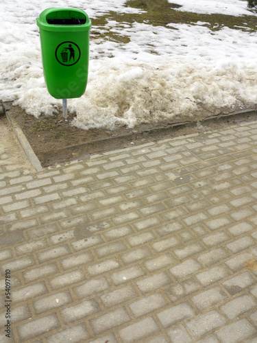Photo: Green pastic garbage bin or can on street Green pastic garbage bin or can on street