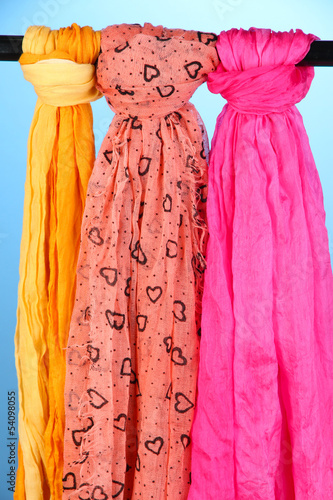 Photo: Colored scarves on blue background Colored scarves on blue background