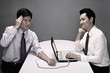 Photo: Businessman transferring blood from his hand to laptop through IV drip tube, another businessman monitoring the laptop Businessman transferring blood from his hand to laptop through IV drip tube, another businessman monitoring the laptop
