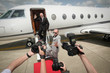 Photo: Businessman descending from private jet with his bodyguard, paparazzi taking photographs Businessman descending from private jet with his bodyguard, paparazzi taking photographs