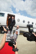 Photo: Businessman descending from private jet with his bodyguard, paparazzi taking photographs Businessman descending from private jet with his bodyguard, paparazzi taking photographs