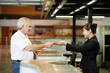Photo: Airline check-in attendant returning businessman's passport at the airport check-in counter Airline check-in attendant returning businessman's passport at the airport check-in counter