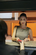 Photo: Airline check-in attendant returning businesswoman's passport at the airport check-in counter Airline check-in attendant returning businesswoman's passport at the airport check-in counter