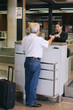 Photo: Airline check-in attendant returning businessman's passport at the airport check-in counter Airline check-in attendant returning businessman's passport at the airport check-in counter