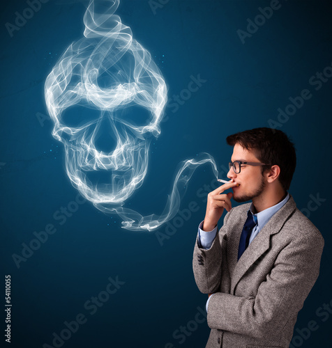 Photo: Young man smoking dangerous cigarette with toxic skull smoke Young man smoking dangerous cigarette with toxic skull smoke