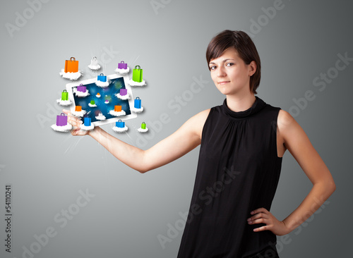 Photo: woman holding modern tablet with colorful shopping bags on cloud woman holding modern tablet with colorful shopping bags on cloud