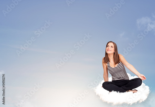 Photo: Young woman sitting on cloud with copy space Young woman sitting on cloud with copy space