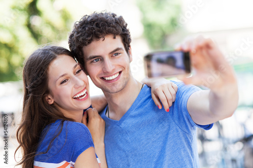 Photo: Couple taking photo of themselves Couple taking photo of themselves