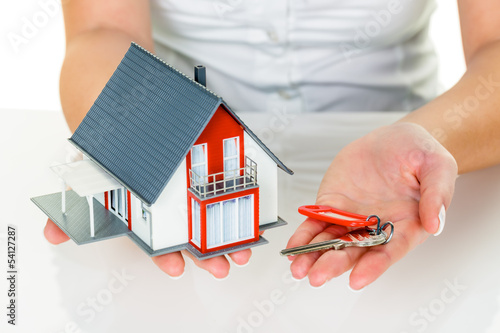 Photo: Immobilienmaklerin mit Haus und Schlüßel Immobilienmaklerin mit Haus und Schlüßel