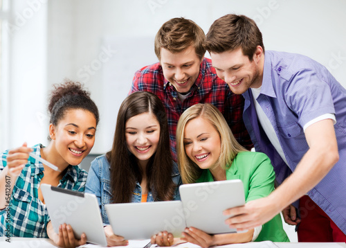 Photo: students looking at tablet pc in lecture at school students looking at tablet pc in lecture at school