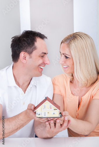 Photo: Couple holding house model Couple holding house model