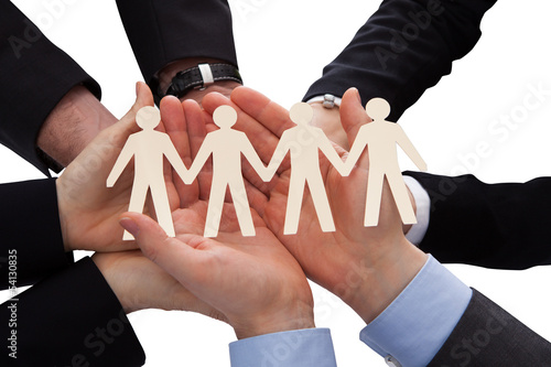 Photo: Businesspeople Holding Human Figure Cutout Businesspeople Holding Human Figure Cutout