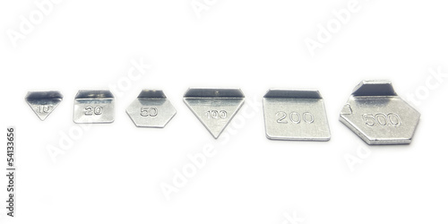 Photo: Six small calibration weights on white background Six small calibration weights on white background
