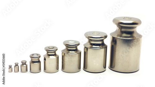 Photo: Eight calibration weights on white background Eight calibration weights on white background