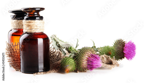 Photo: Medicine bottles with thistle flowers, isolated on white Medicine bottles with thistle flowers, isolated on white