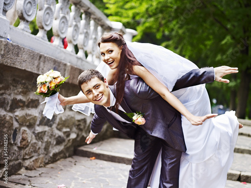 Photo: Groom carries his bride over back. Groom carries his bride over back.