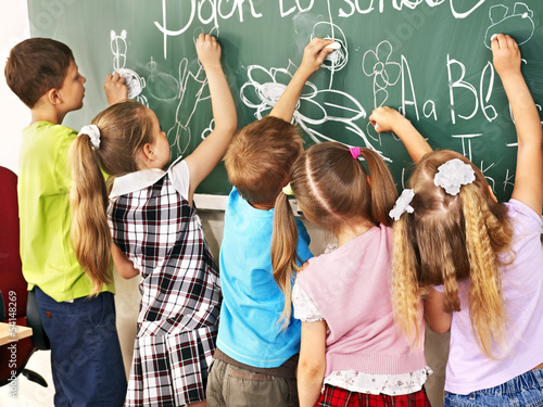 Photo: Children writing on blackboard. Children writing on blackboard.
