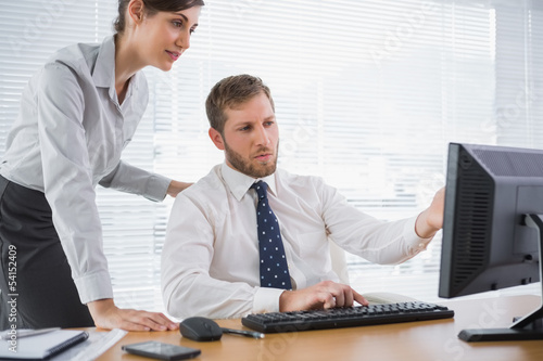 Photo: Businessman showing his colleague something on computer Businessman showing his colleague something on computer