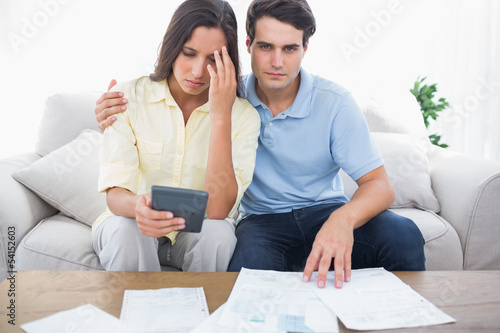 Photo: Anxious couple doing their accounts Anxious couple doing their accounts