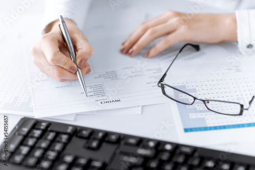 Photo: woman hand filling in invoice paper woman hand filling in invoice paper