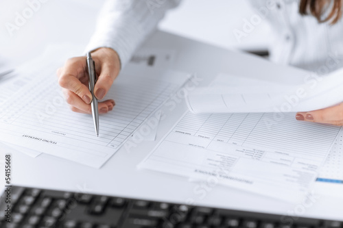 Photo: woman hand filling in blank paper or document woman hand filling in blank paper or document