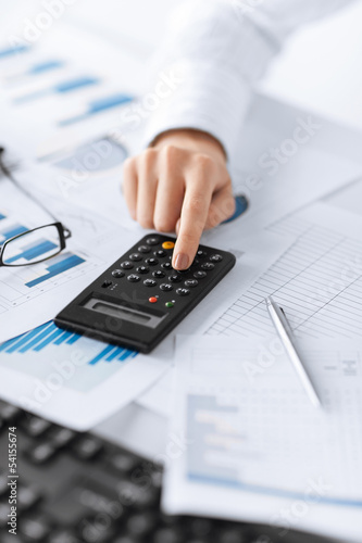 Photo: woman hand with calculator and papers woman hand with calculator and papers