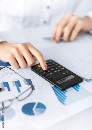 Photo: woman hand with calculator and papers woman hand with calculator and papers