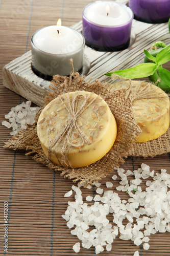 Photo: Hand-made soap and sea salt on grey bamboo mat Hand-made soap and sea salt on grey bamboo mat
