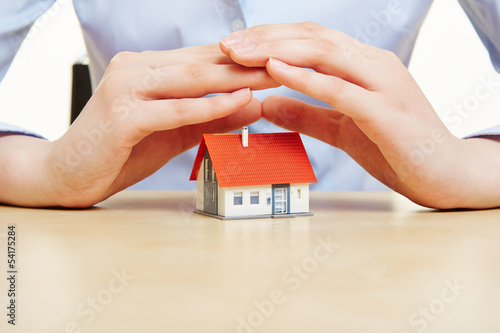 Photo: Hände halten schützend Dach über ein Haus Hände halten schützend Dach über ein Haus