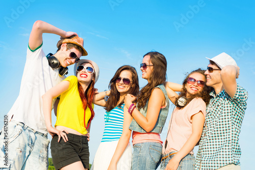 Photo: group of young people wearing sunglasses and hat group of young people wearing sunglasses and hat