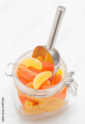 Photo: orange and lemon jelly beans in glass jar with scoop orange and lemon jelly beans in glass jar with scoop