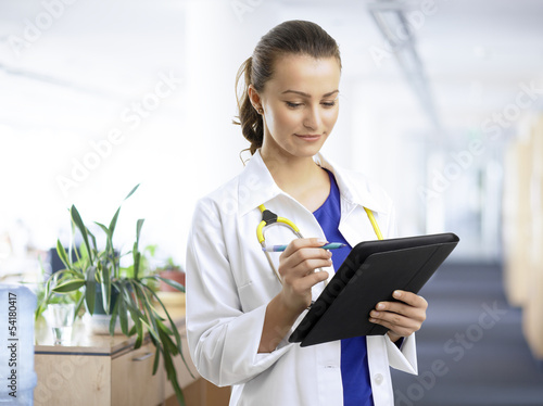 Photo: Beautiful female doctor examining the patient chart Beautiful female doctor examining the patient chart