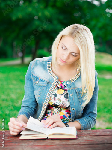 Photo: Beautiful young woman with book in park Beautiful young woman with book in park