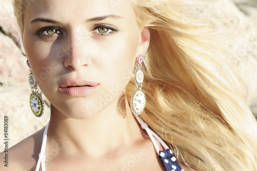 Photo: beautiful mysterious blond young woman. stone background beautiful mysterious blond young woman. stone background