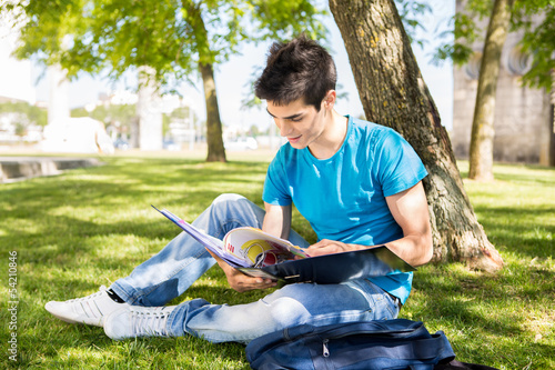 Photo: Young student studying at the school garden Young student studying at the school garden