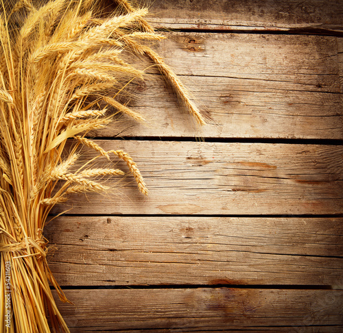 Photo: Wheat Ears on the Wooden Table. Harvest concept Wheat Ears on the Wooden Table. Harvest concept