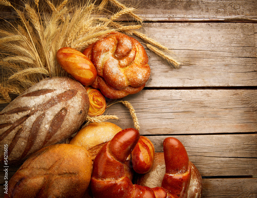 Photo: Bakery Bread and Sheaf over Wood Background Bakery Bread and Sheaf over Wood Background