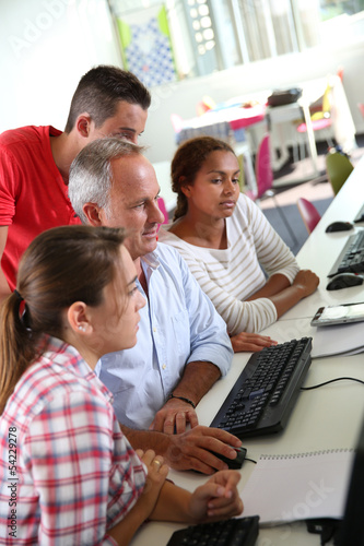 Photo: Teenagers with teacher in computers' class Teenagers with teacher in computers' class