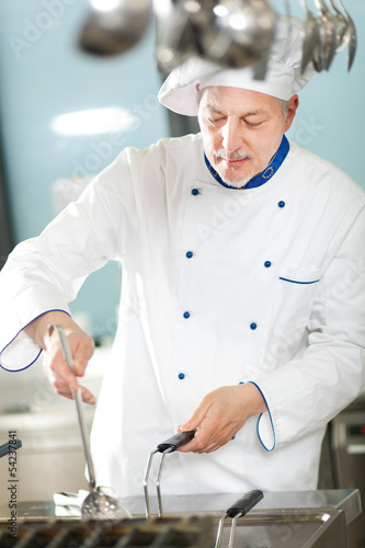 Photo: Mature chef working in a restaurant kitchen Mature chef working in a restaurant kitchen