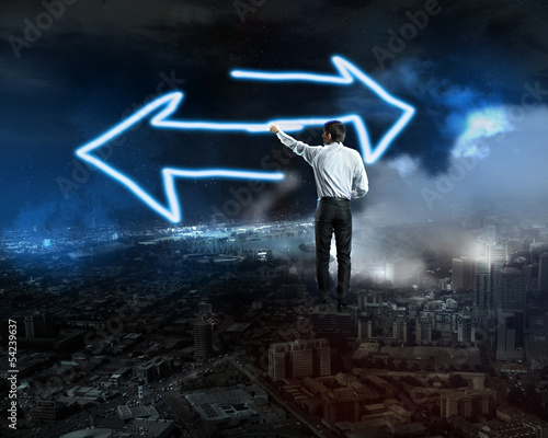 Photo: Businessman draws a glowing signs Businessman draws a glowing signs