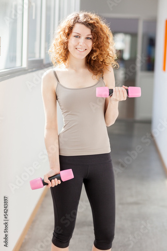 Photo: Young woman doing exercise with dumbbells Young woman doing exercise with dumbbells