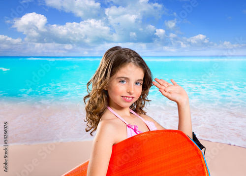 Photo: Children fashion surfer girl in tropical turquoise beach Children fashion surfer girl in tropical turquoise beach