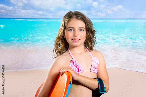 Photo: Children fashion surfer girl in tropical turquoise beach Children fashion surfer girl in tropical turquoise beach