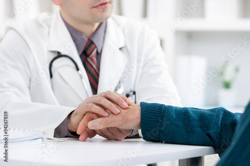 Photo: Doctor holding patient's hand Doctor holding patient's hand