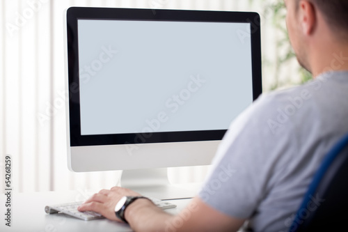 Photo: Man looks at the screen. Man looks at the screen.