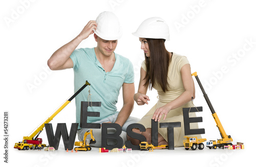Photo: Website under construction: Friendly man and woman building webs Website under construction: Friendly man and woman building webs