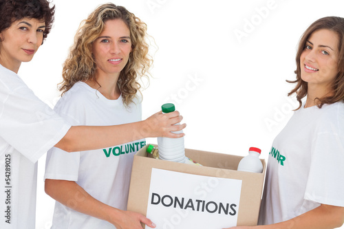 Photo: Volunteer women putting food in donation box Volunteer women putting food in donation box
