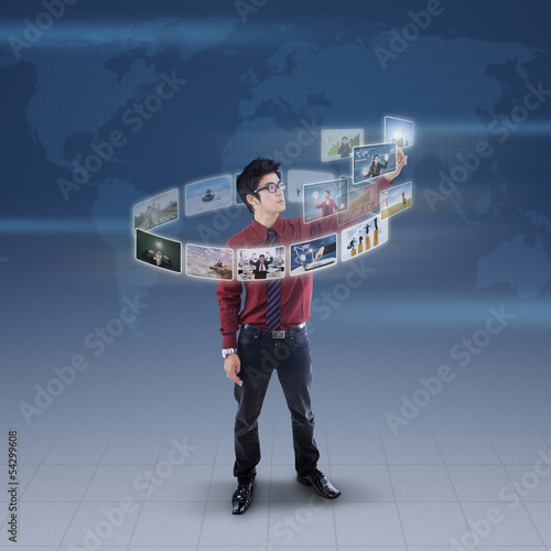 Photo: Businessman touch digital picture on blue world map Businessman touch digital picture on blue world map
